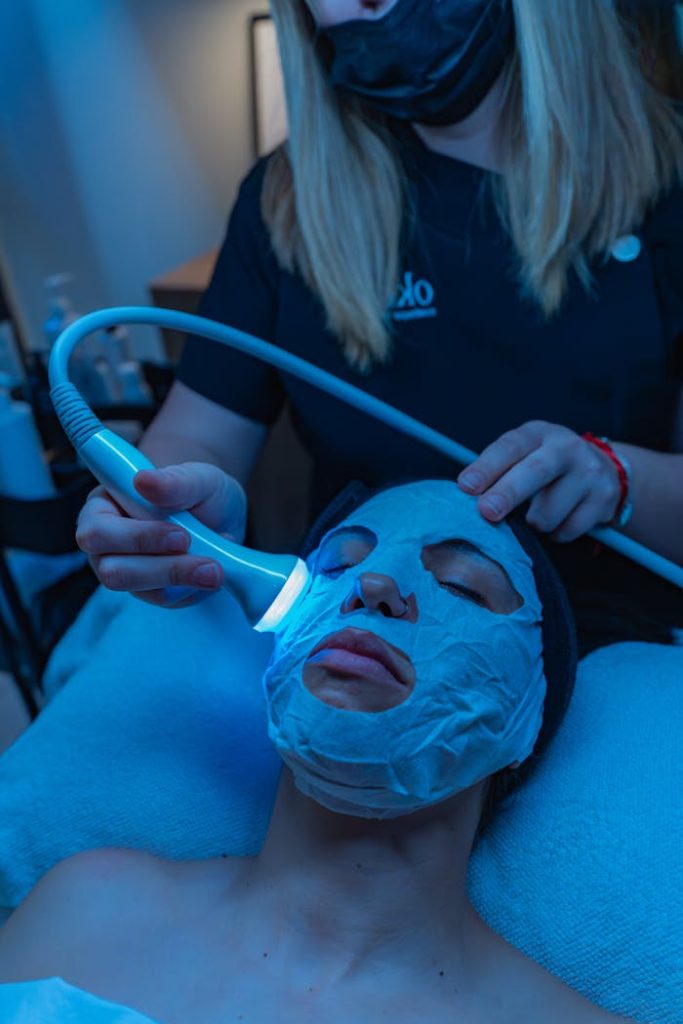 pexels-photo-32078961 A relaxing spa facial treatment with a light therapy device for skincare rejuvenation.